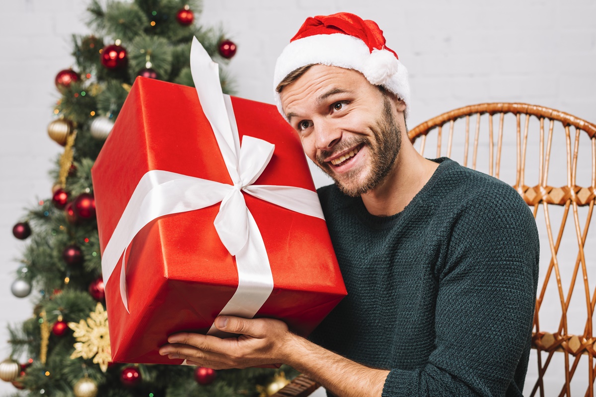man-christmas-hat-holding-present-box